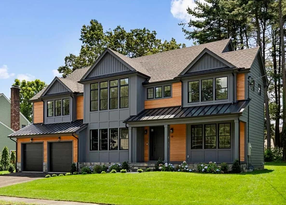 Completed two-story home with gray siding, wood accents and a two-car garage