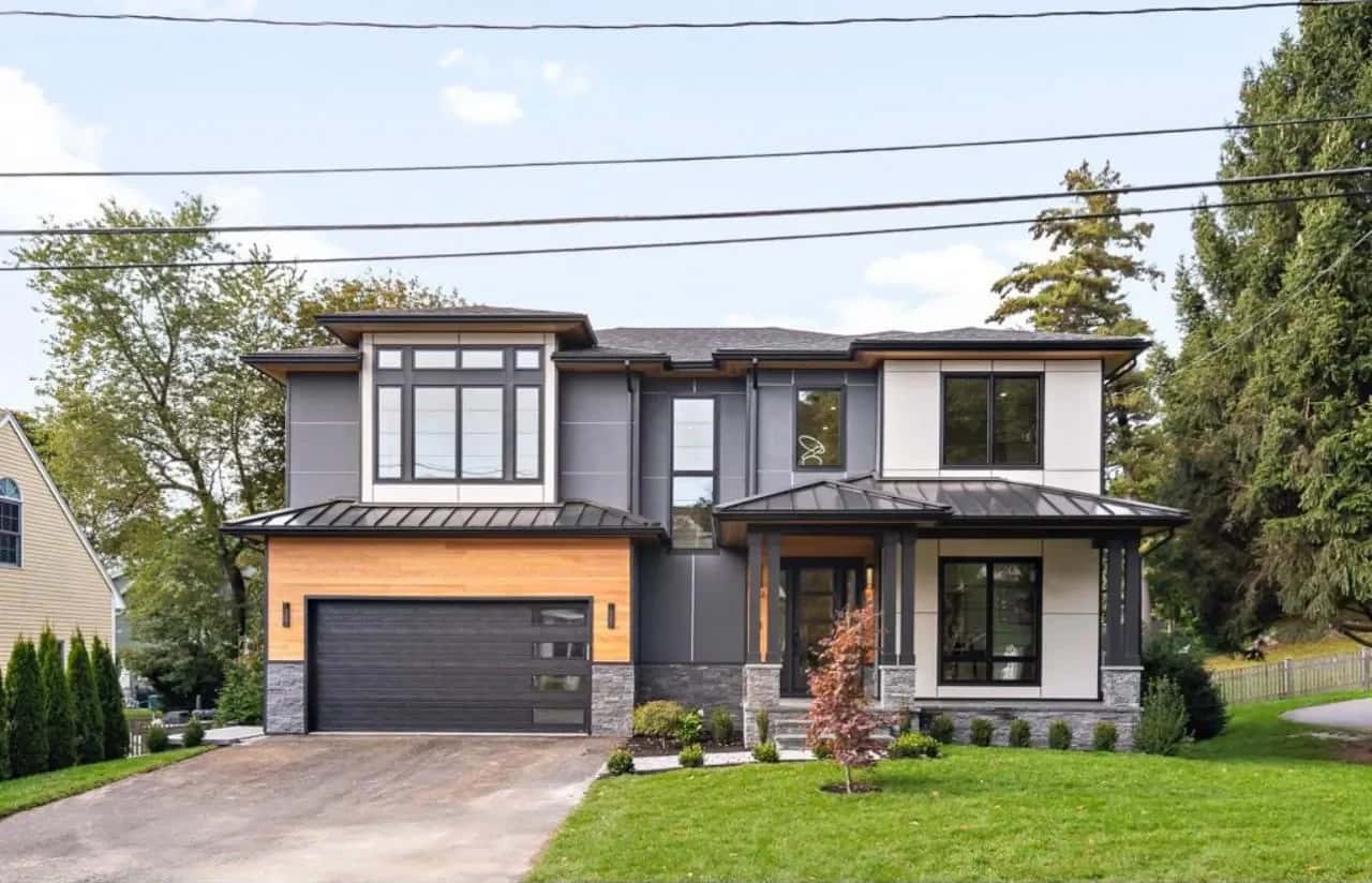 Completed contemporary home with a standing-seam metal roof and a wood-clad garage